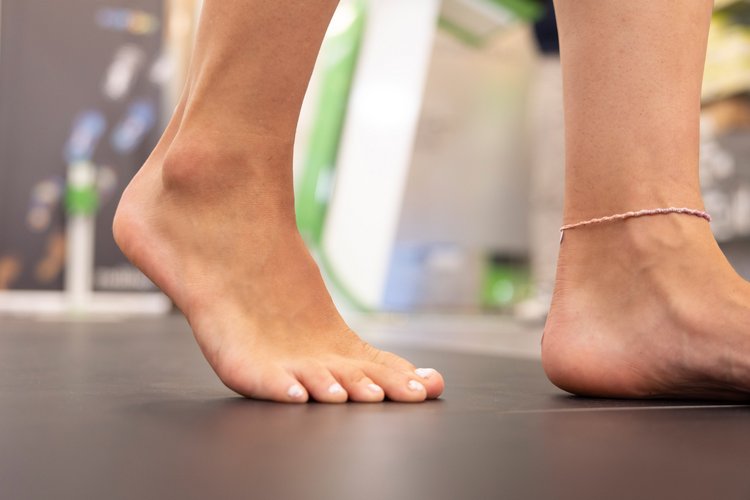 Eine barfüßige Person geht auf einer Messfläche zur Erfassung des natürlichen Gangbildes