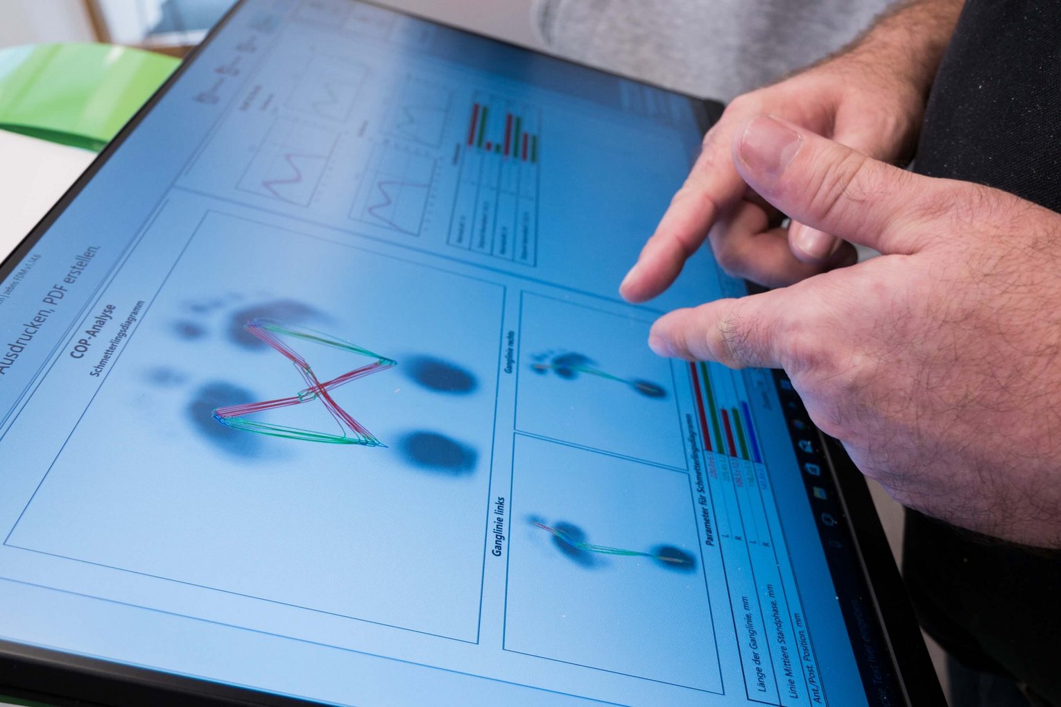 Zwei Hände bedienen einen Touchscreen mit 3D-Visualisierung einer Fußstruktur zur digitalen Vermessung