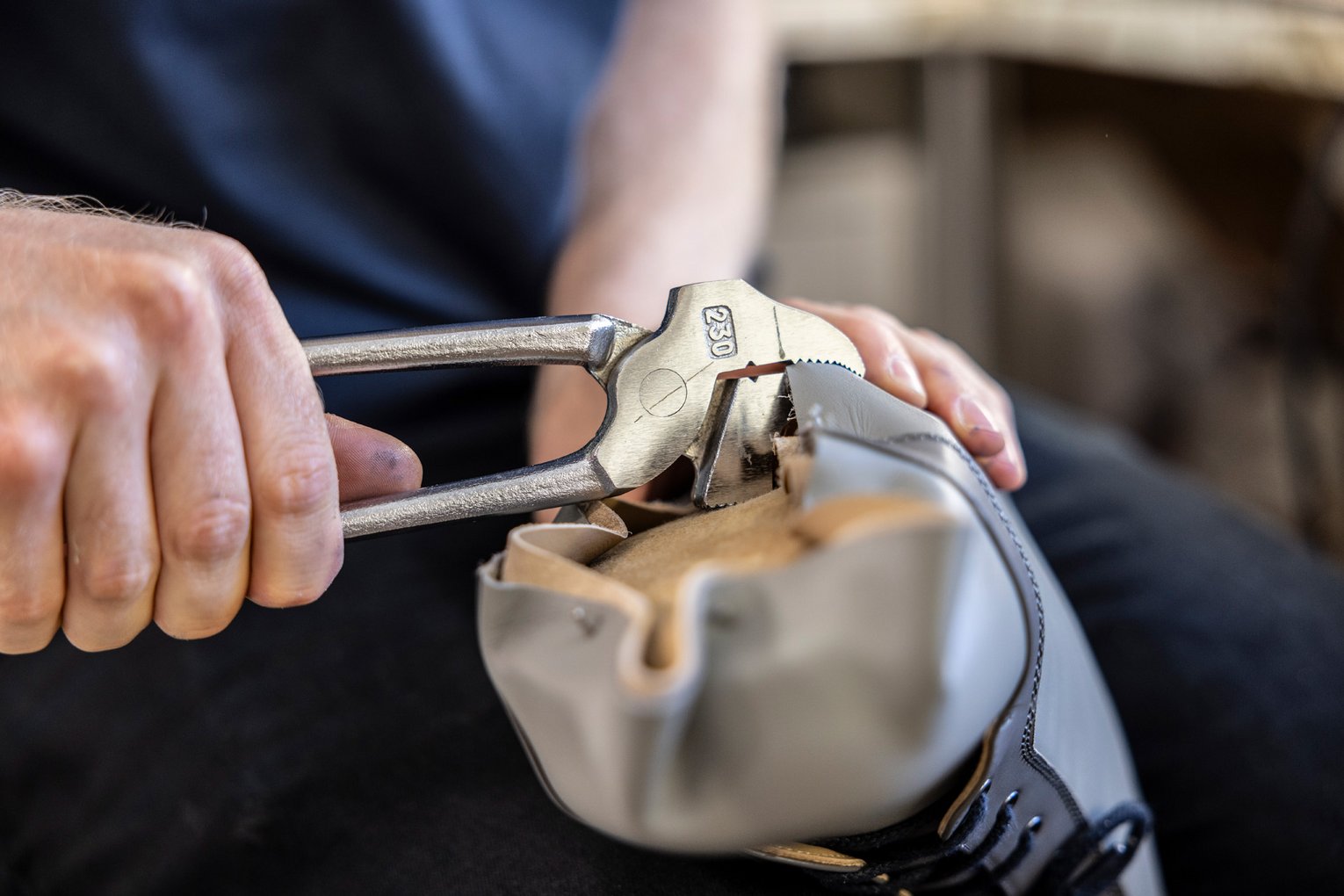 Nahaufnahme eines handwerklichen Arbeitsschritts an einem Schuh mit Werkzeug – individuelle Anpassung für orthopädische Zwecke